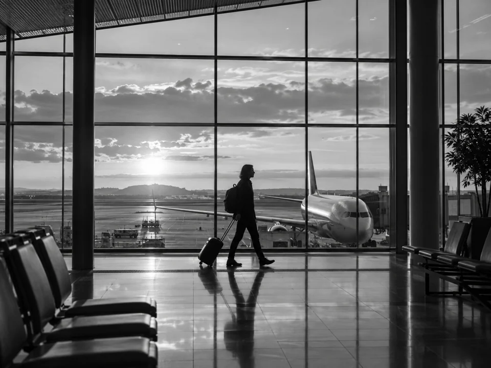 A traveller pulling a suitcase through an airport terminal.
